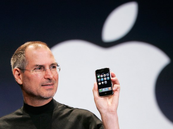 Former Apple CEO Steve Jobs holds up an Apple iPhone at the MacWorld Conference in San Francisco on January 9, 2007.PAUL SAKUMA/AP